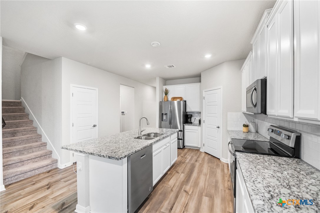 232 Colebrook Way Cibolo, TX 78108 - Photo 8 of 42 a large white kitchen with stainless steel appliances granite countertop a stove and a sink