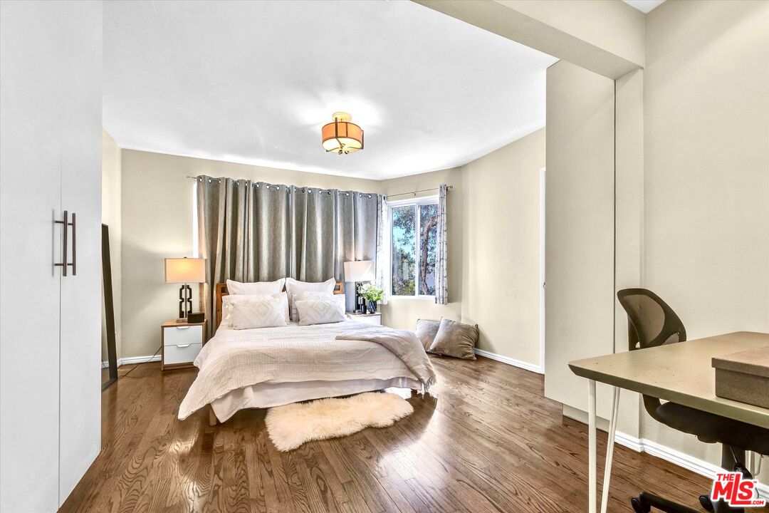 11670 Sunset Boulevard, Unit 303 Los Angeles, CA 90049 - Photo 15 of 32 a bedroom with a bed and wooden floor