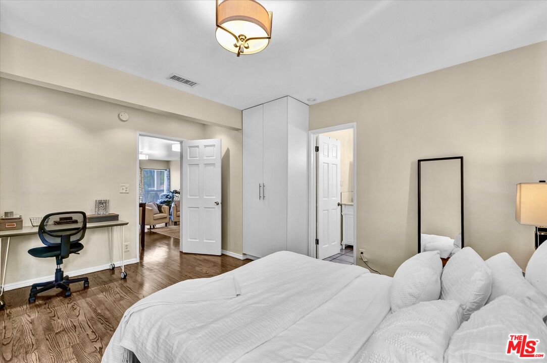 11670 Sunset Boulevard, Unit 303 Los Angeles, CA 90049 - Photo 16 of 32 a bedroom with a bed and a chandelier