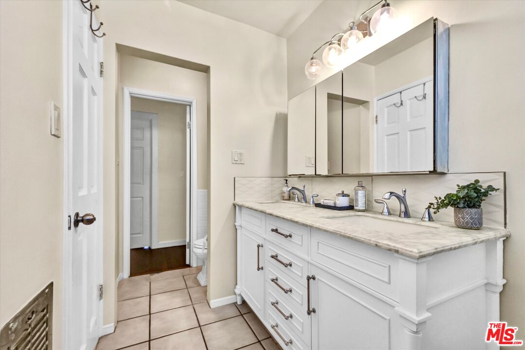 11670 Sunset Boulevard, Unit 303 Los Angeles, CA 90049 - Photo 17 of 32 a bathroom with a sink a vanity and a mirror