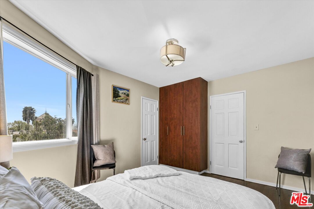 11670 Sunset Boulevard, Unit 303 Los Angeles, CA 90049 - Photo 19 of 32 a bedroom with a bed and a window
