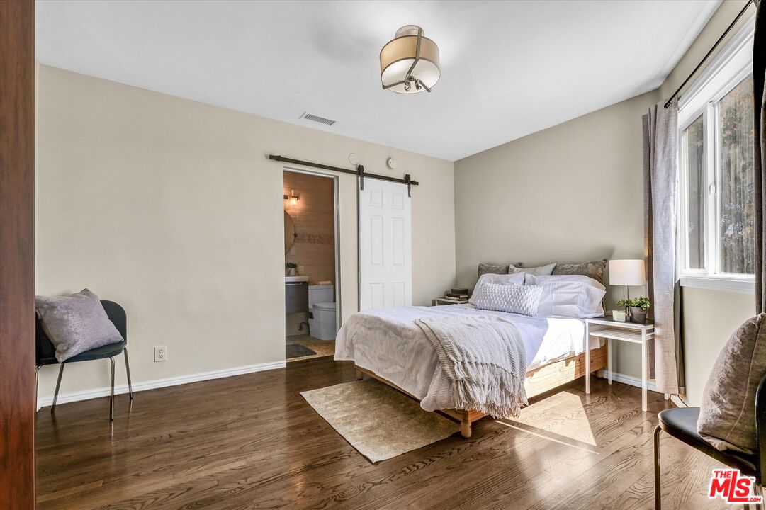 11670 Sunset Boulevard, Unit 303 Los Angeles, CA 90049 - Photo 20 of 32 a bedroom with a bed and wooden floor