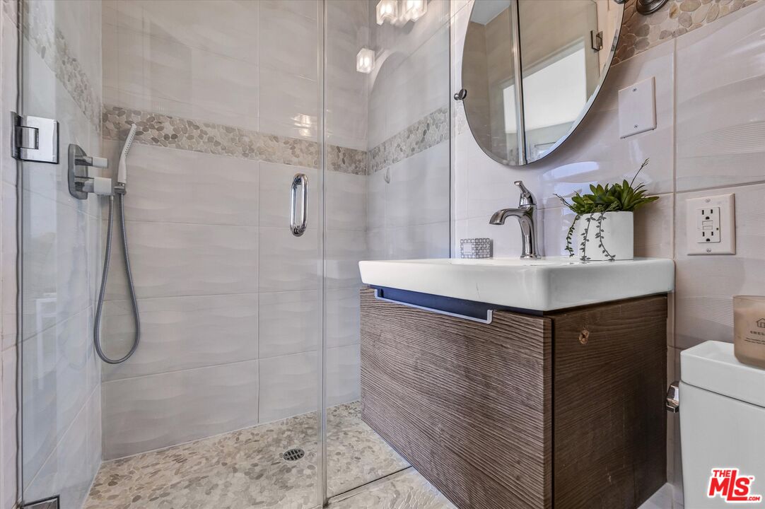 11670 Sunset Boulevard, Unit 303 Los Angeles, CA 90049 - Photo 21 of 32 a bathroom with a sink vanity and a mirror