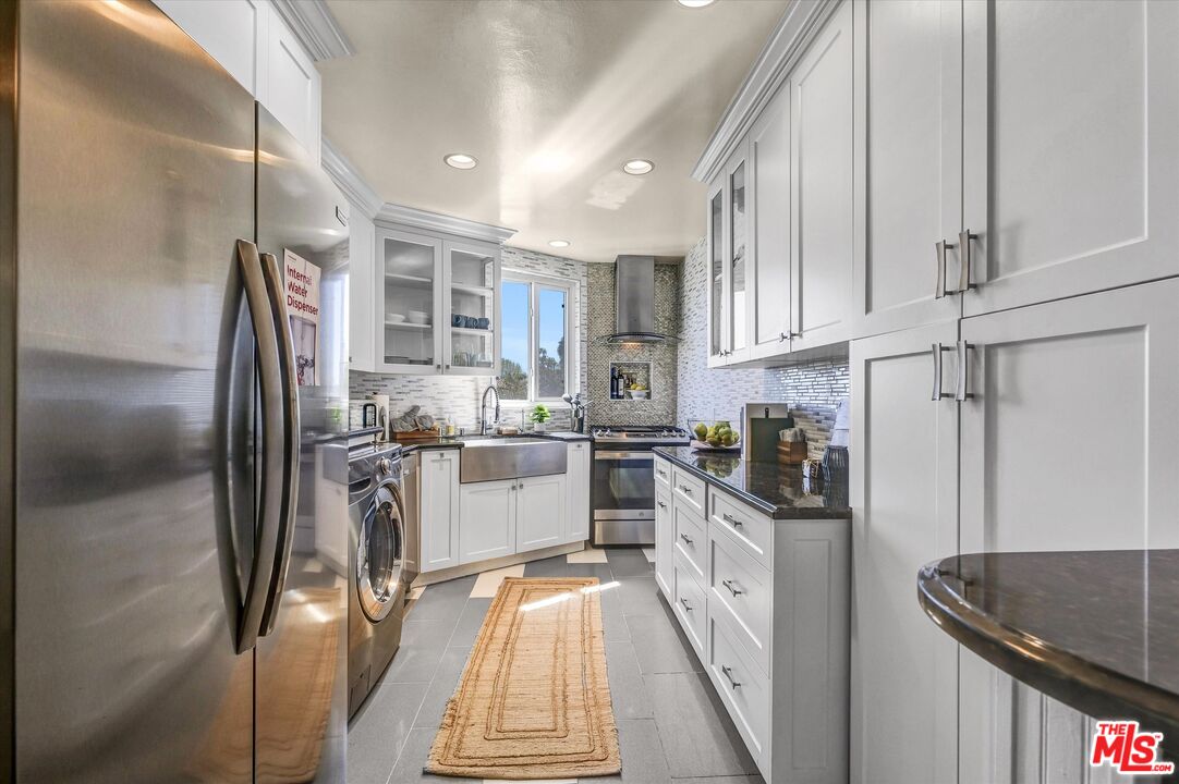 11670 Sunset Boulevard, Unit 303 Los Angeles, CA 90049 - Photo 3 of 32 a kitchen with stainless steel appliances granite countertop a refrigerator and a stove