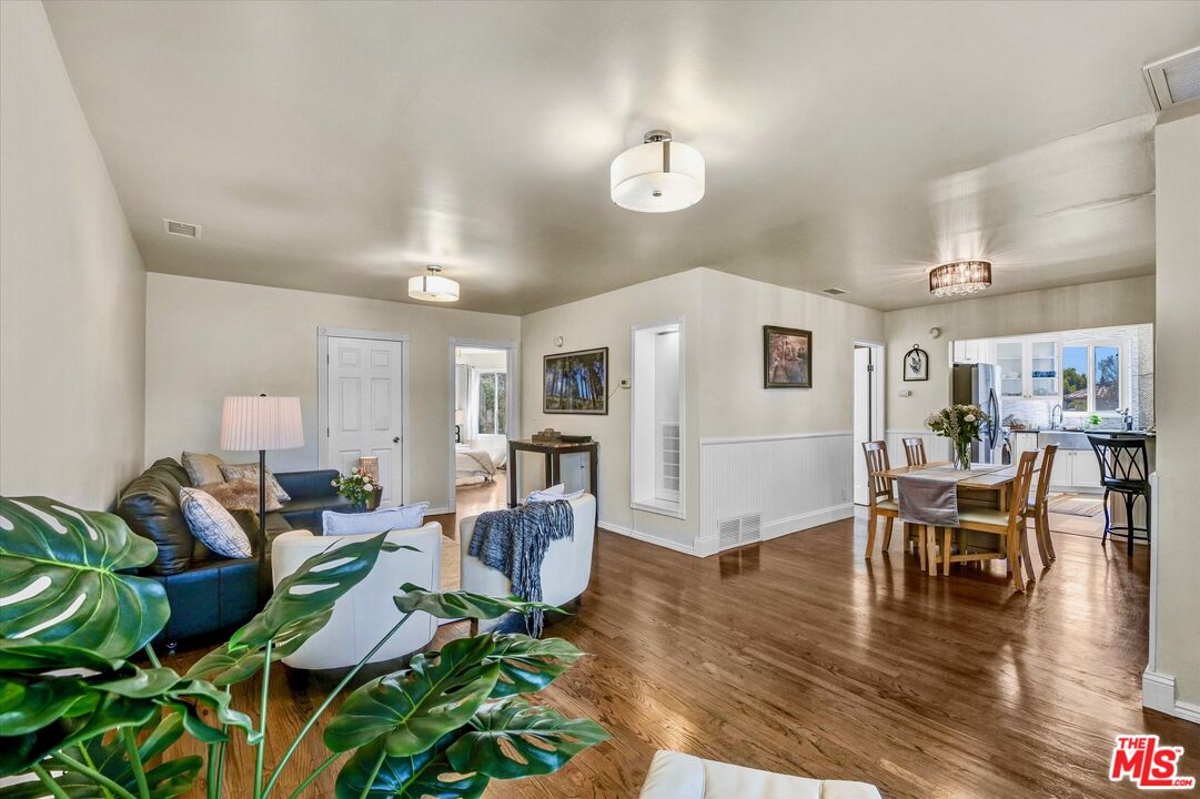 11670 Sunset Boulevard, Unit 303 Los Angeles, CA 90049 - Photo 10 of 32 a living room with furniture dining table and a potted plant