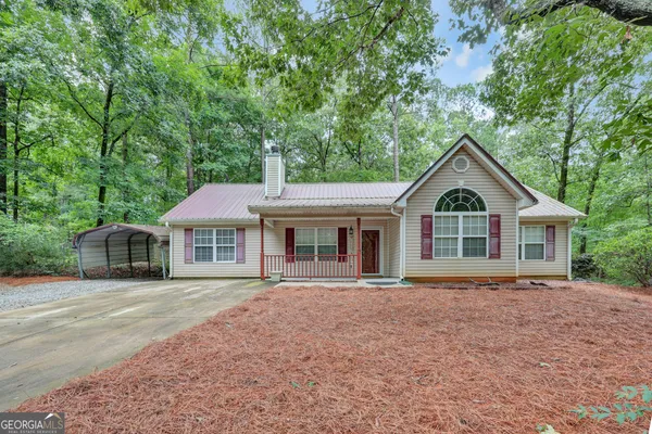 a front view of a house with a yard and trees
