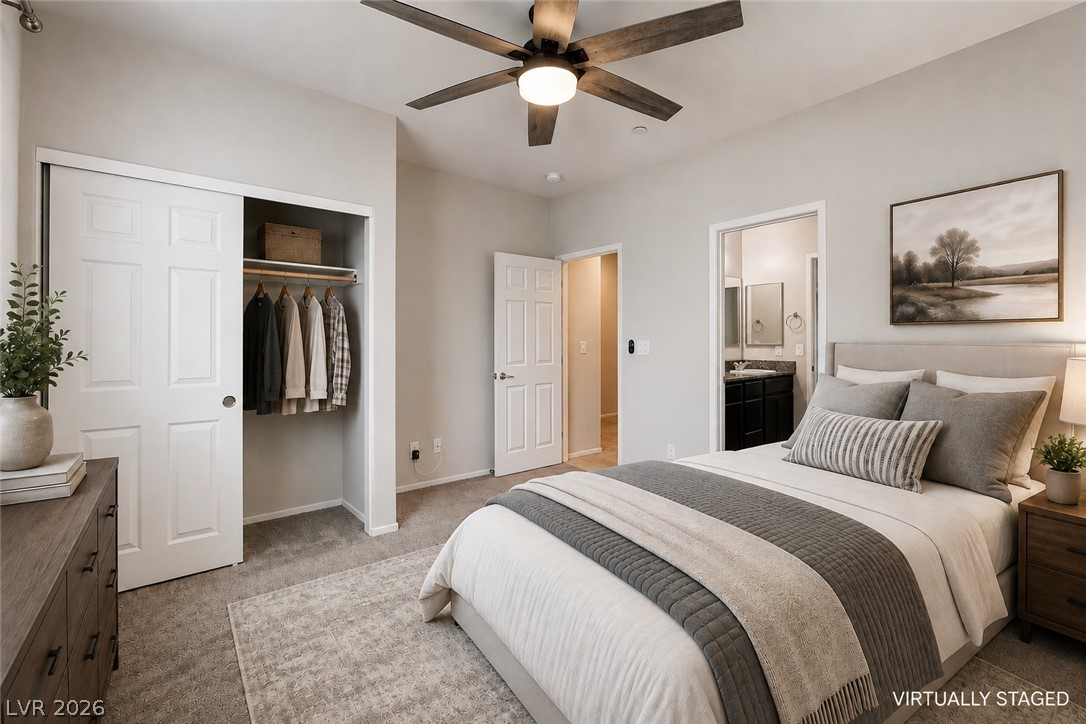 2185 Rio Rancho Pointe Place Henderson, NV 89002 - Photo 9 of 17 A comfortable bedroom features a ceiling fan, soft carpeting, and convenient access to an en-suite bathroom.