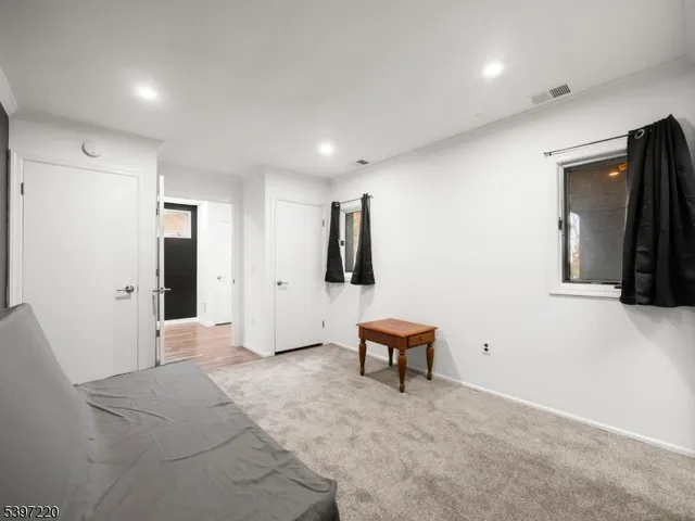 a view of an empty room with wooden floor and furniture
