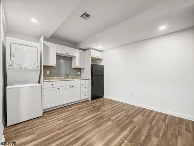 a kitchen with a refrigerator and white cabinets