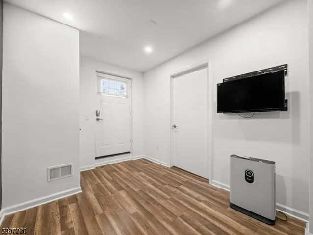 a view of a livingroom with wooden floor and a flat screen tv