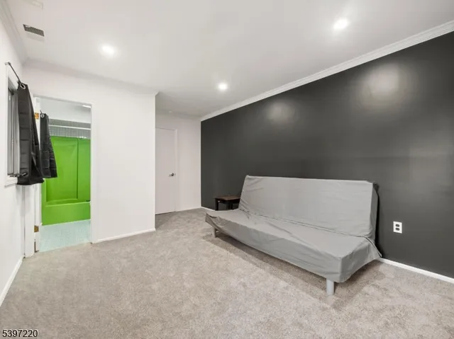 a living room with a bed furniture and a night stand