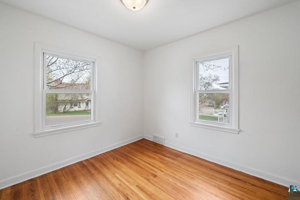 122 3rd Street Cloquet, MN 55720 - Photo 8 of 42 Room featuring wood-finish flooring, white painted walls, and two single-hung windows with white trim