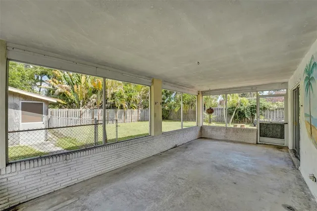 a view of an empty room with wooden floor and a large window
