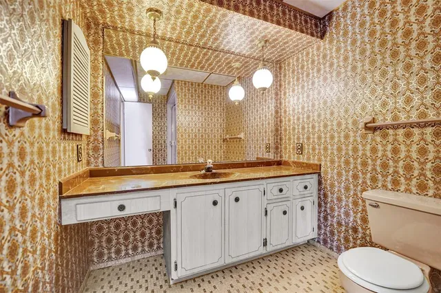 a bathroom with a double vanity sink and a toilet