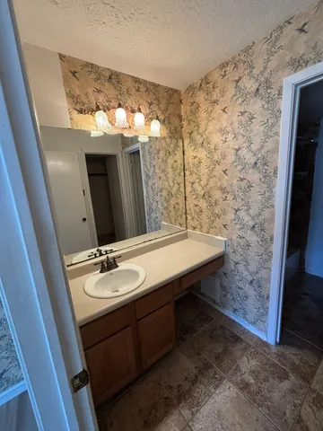 a bathroom with a granite countertop sink a mirror and shower