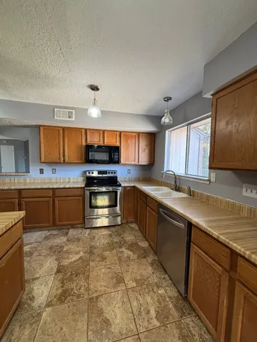 a kitchen with stainless steel appliances granite countertop a stove sink and cabinets