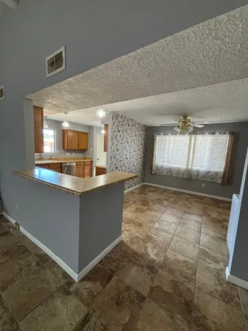 a kitchen with kitchen island granite countertop a sink and a stove top oven