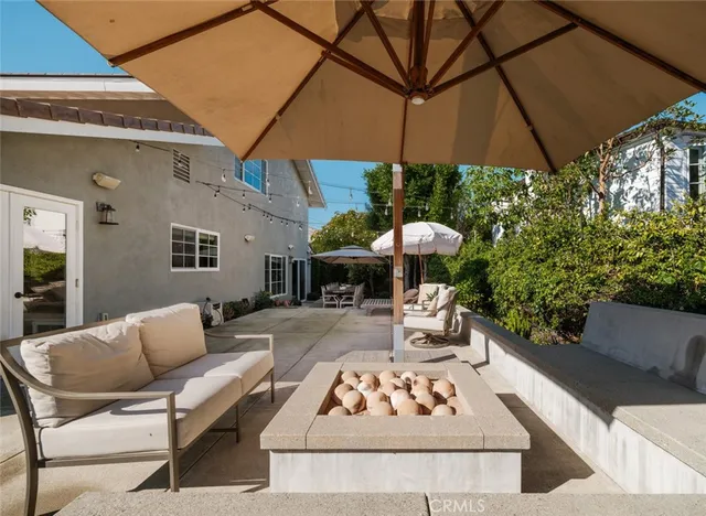 a view of a patio with a table and chairs under an umbrella