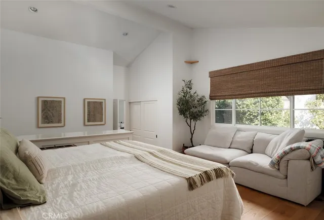 a bedroom with a large bed couch and window