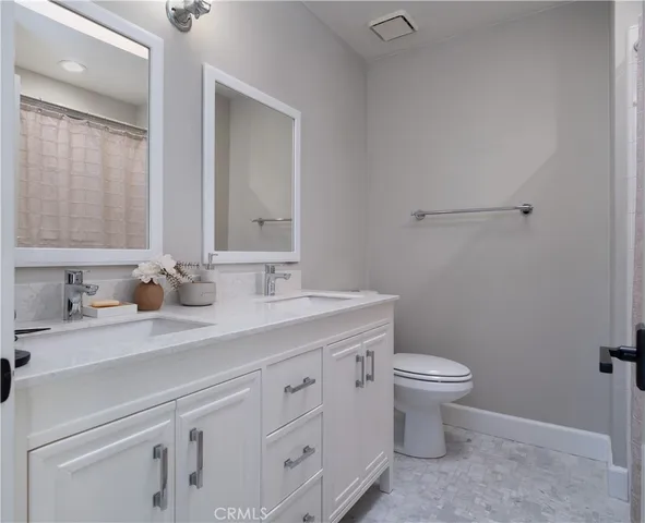 a bathroom with a sink a toilet and a mirror