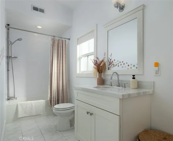 a bathroom with a granite countertop sink toilet a mirror and shower