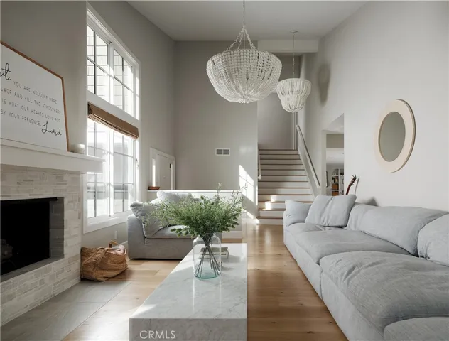 a living room with furniture chandelier and a fireplace