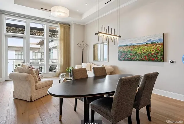 a view of a dining room with furniture a large window and wooden floor