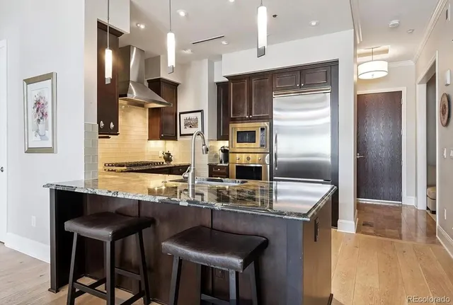 a kitchen with stainless steel appliances granite countertop a sink refrigerator and cabinets