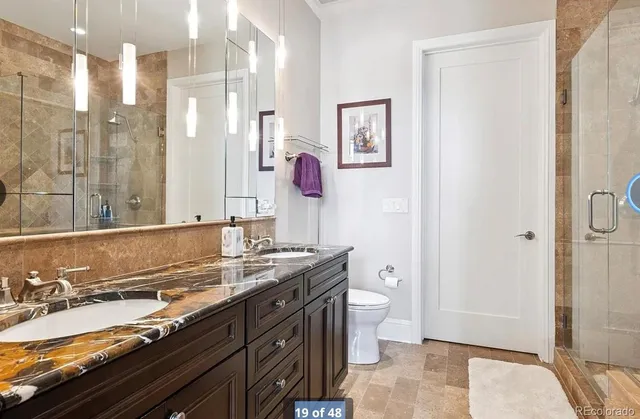 a spacious bathroom with a granite countertop sink toilet and shower