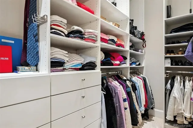 a view of walk in closet with clothes and shoes