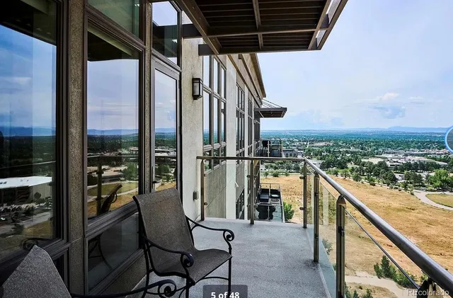 a view of a balcony with chair and wooden floor