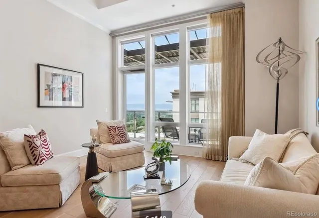 a living room with furniture and floor to ceiling windows