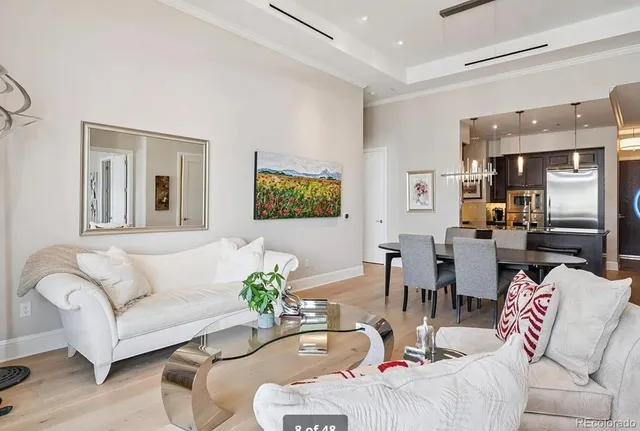 a living room with furniture kitchen view and a window