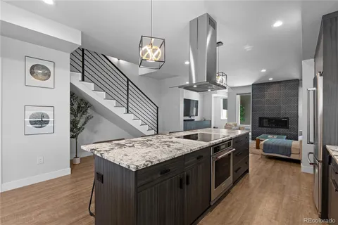 a kitchen with stainless steel appliances a table chairs refrigerator and wooden floor