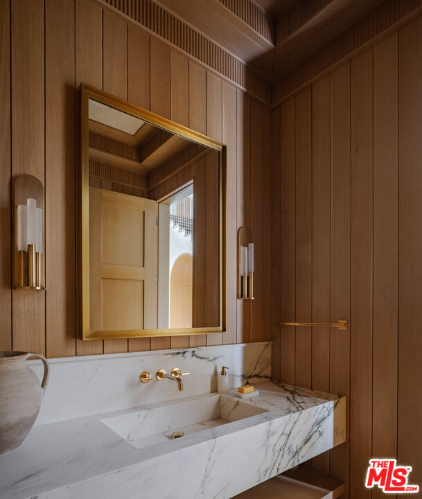 250 South Rockingham Avenue Los Angeles, CA 90049 - Photo 11 of 20 a bathroom with a granite countertop sink and a mirror