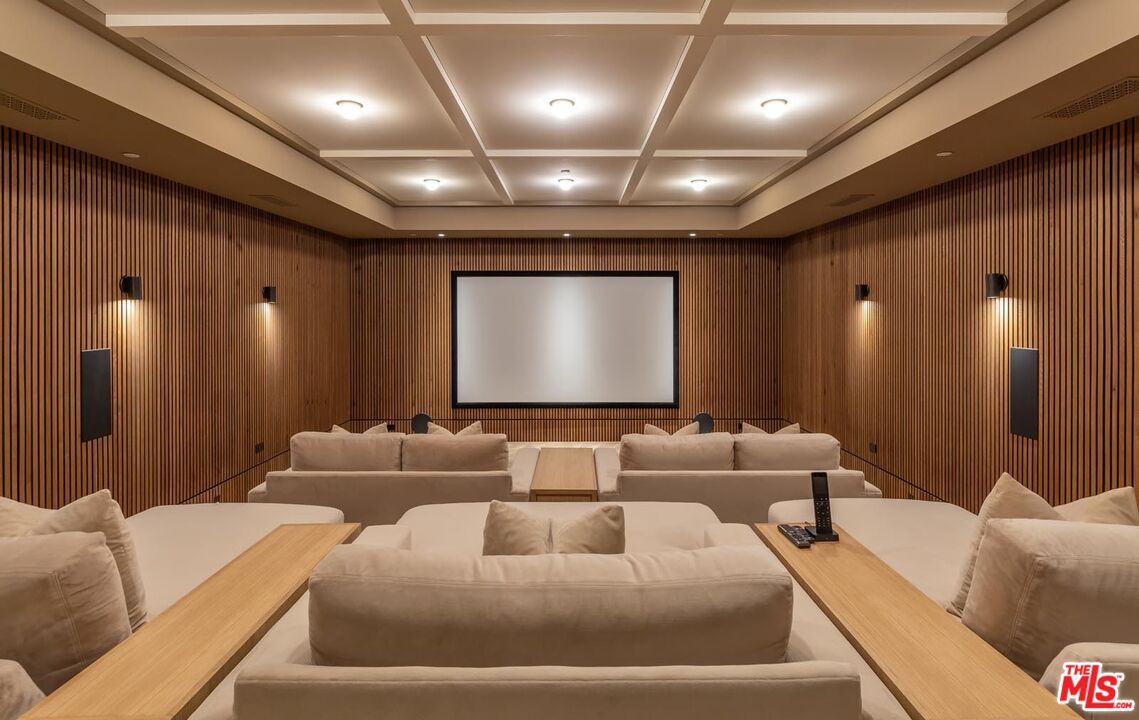 250 South Rockingham Avenue Los Angeles, CA 90049 - Photo 15 of 20 a projector room with large couches and a projector with a large window