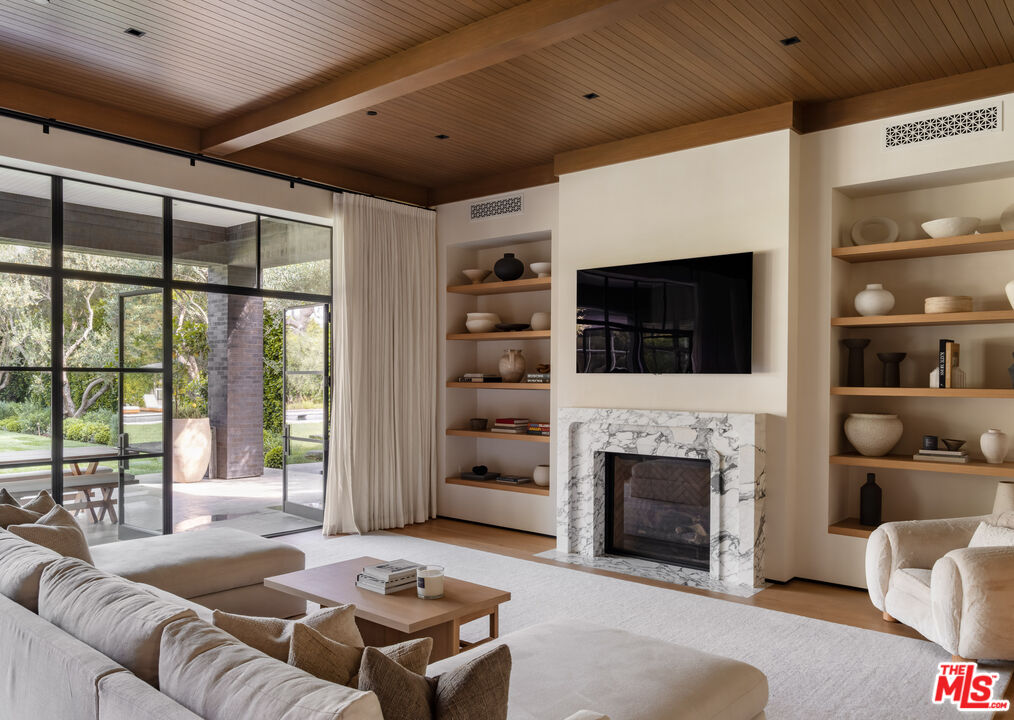 250 South Rockingham Avenue Los Angeles, CA 90049 - Photo 5 of 20 a living room with furniture a flat screen tv and a fireplace