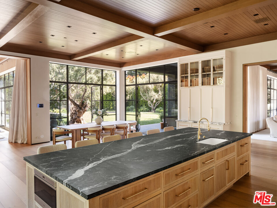 250 South Rockingham Avenue Los Angeles, CA 90049 - Photo 7 of 20 a kitchen with granite countertop a sink and a large window