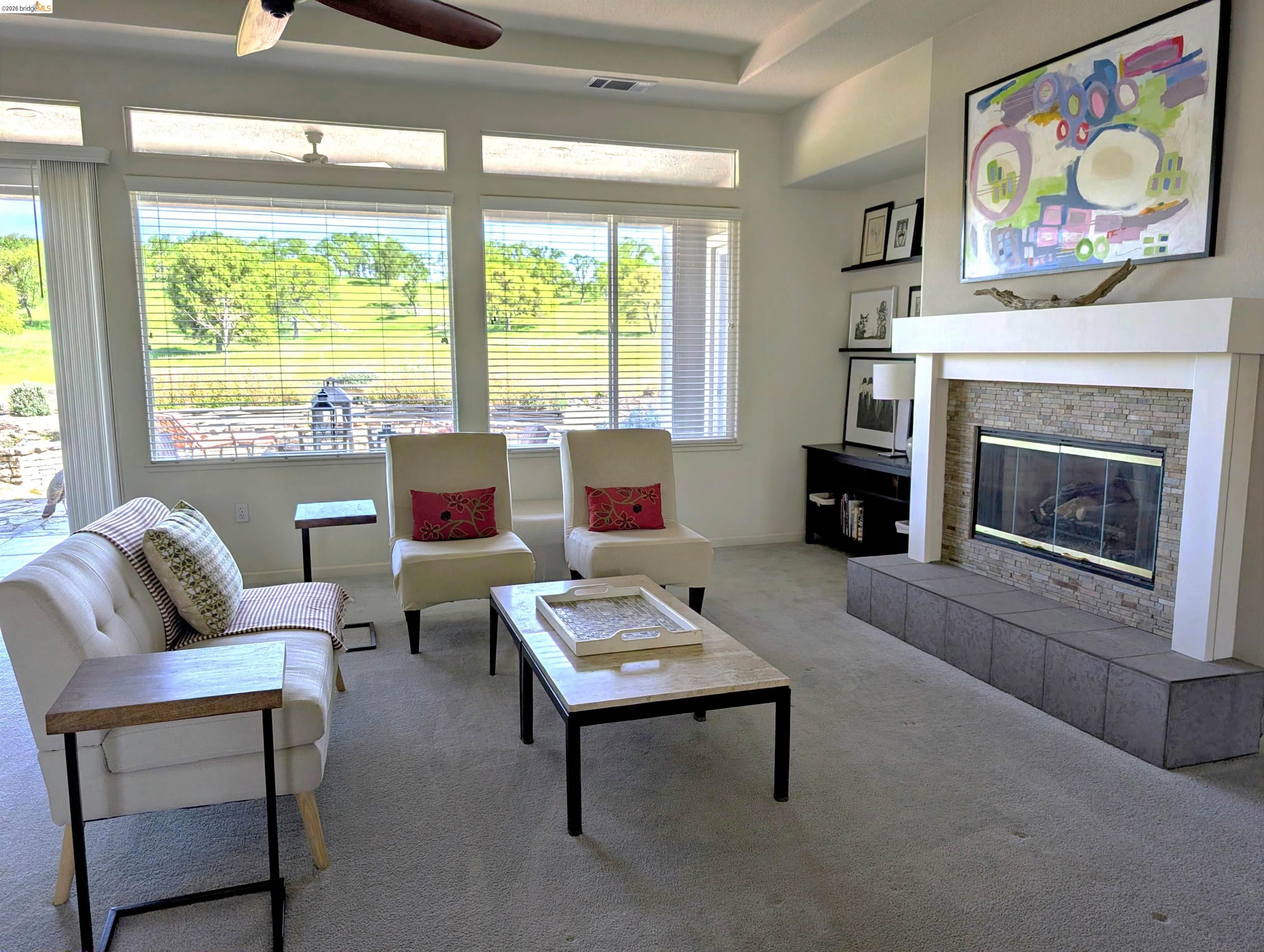 258 Rock Ridge Lane Copperopolis, CA 95228 - Photo 21 of 47 Living area featuring a tile fireplace, carpet flooring, and ceiling fan
