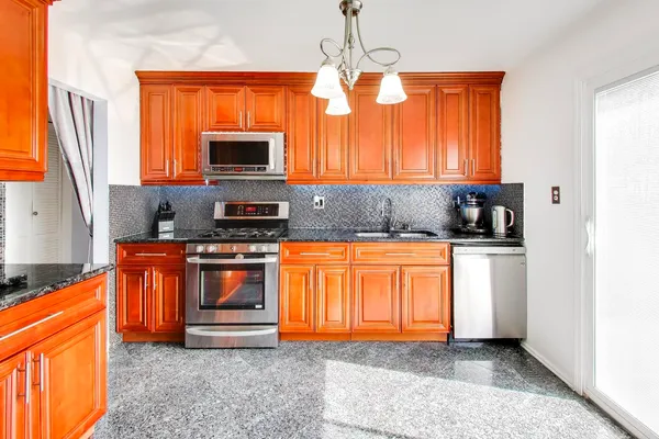a kitchen with stainless steel appliances granite countertop a stove a sink and a refrigerator