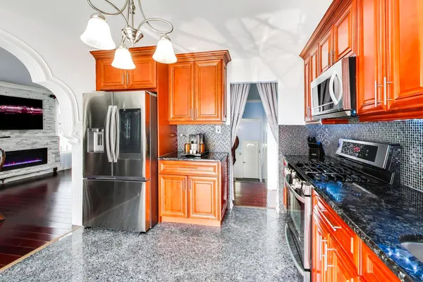 a kitchen with stainless steel appliances granite countertop a refrigerator a stove top oven a sink and dishwasher