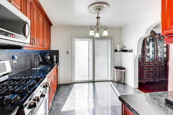 a kitchen with stainless steel appliances granite countertop a stove and a wooden cabinets