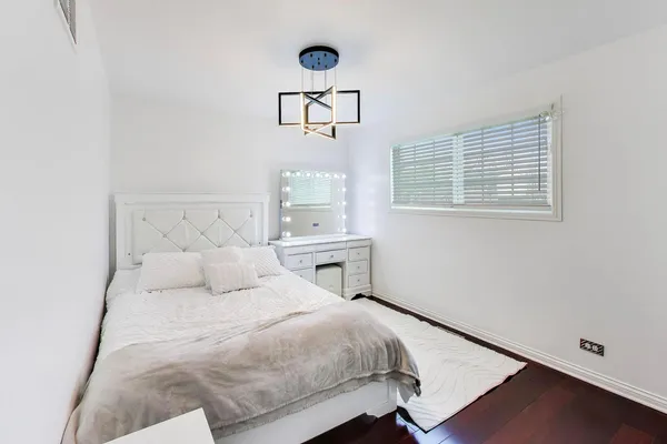 a bedroom with a bed and painting on the wall