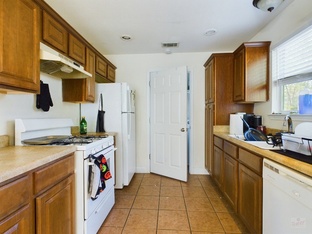 500 East 48th Street, Unit B Austin, TX 78751 - Photo 6 of 32 a kitchen with a sink a stove top oven a refrigerator and a window