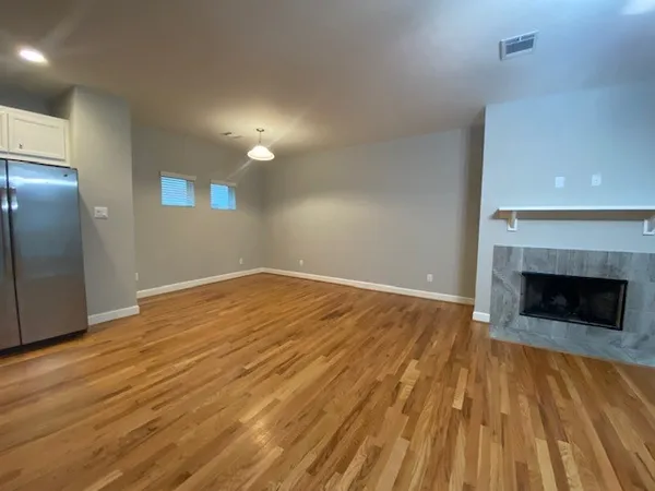 a view of empty room with wooden floor and fireplace