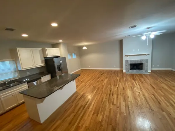 a living room with stainless steel appliances furniture a fireplace and a flat screen tv