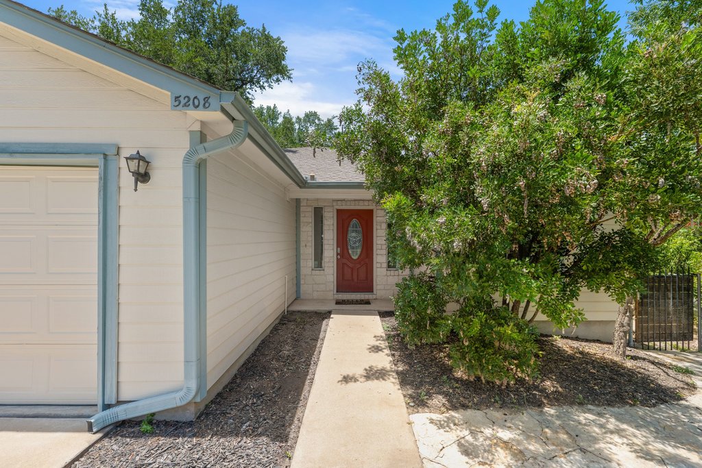 5208 Sioux Lane Austin, TX 78734 - Photo 3 of 35 A vibrant red front door welcomes guests to this inviting facade.