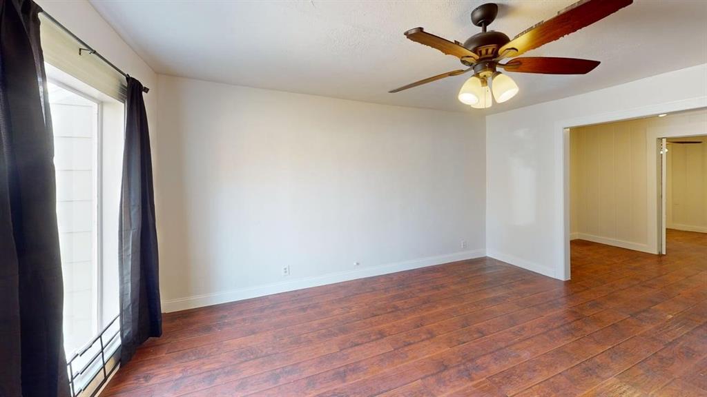 2246 Anson Road Dallas, TX 75235 - Photo 4 of 20 Spacious room featuring wood-finish flooring, white walls, and a ceiling fan with integrated lighting