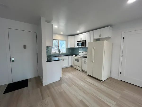 a kitchen with stainless steel appliances a refrigerator sink and cabinets
