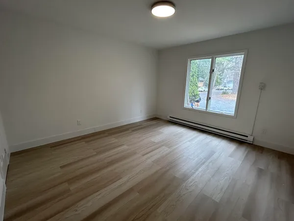 a view of a livingroom with wooden floor and window